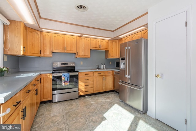 kitchen featuring stainless steel appliances, visible vents, a sink, crown molding, and light countertops