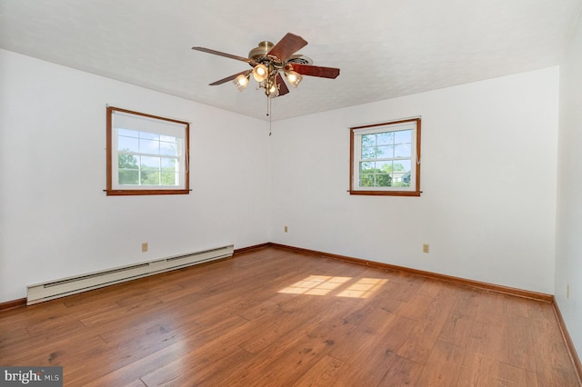 unfurnished room with a healthy amount of sunlight, a ceiling fan, baseboard heating, and wood finished floors