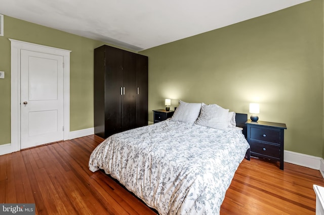 bedroom featuring baseboards and wood finished floors