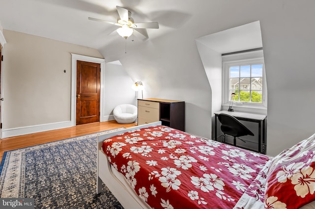 bedroom featuring vaulted ceiling, wood finished floors, baseboards, and ceiling fan