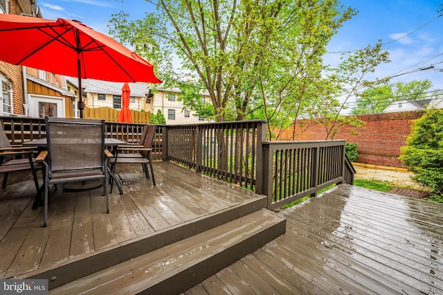wooden terrace with outdoor dining area and fence