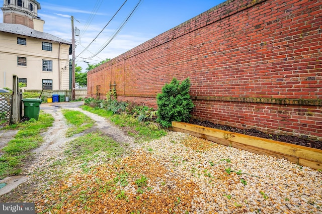 view of home's exterior with fence and brick siding
