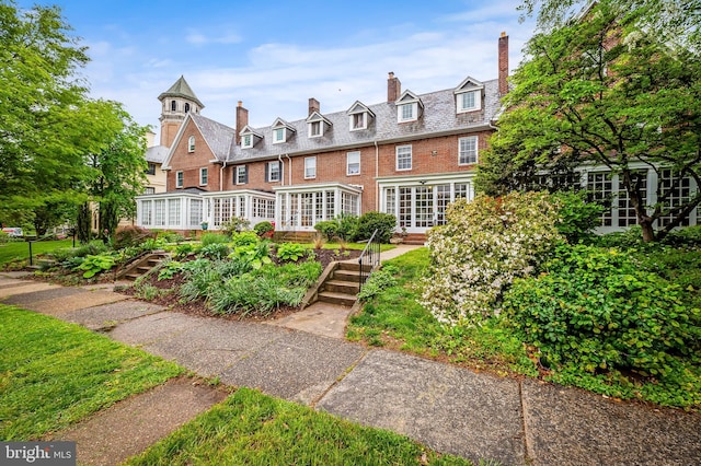view of front of house with brick siding and a chimney
