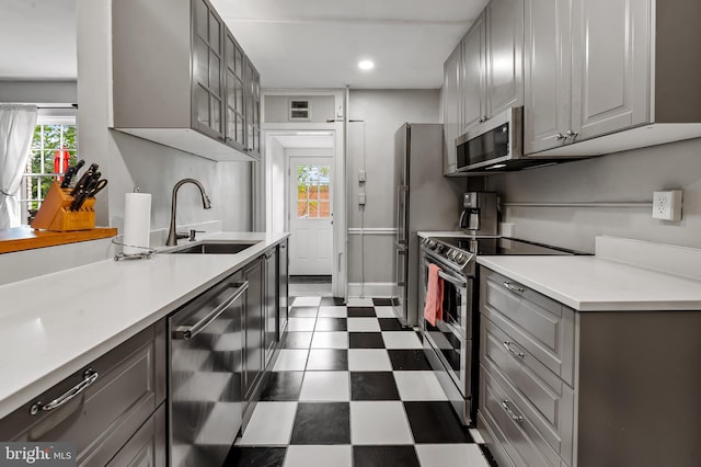 kitchen featuring a sink, dark floors, gray cabinets, appliances with stainless steel finishes, and recessed lighting