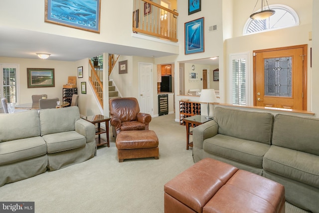 6018 Good Lion Ct, Alexandria, VA 22315 - living room featuring carpet flooring, stairway, beverage cooler, a towering ceiling, and plenty of natural light