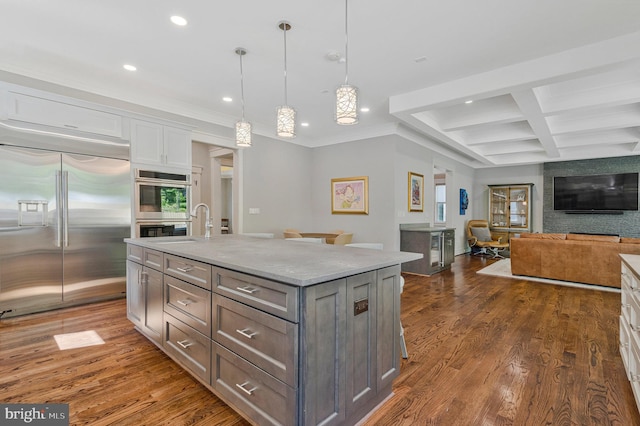 kitchen with appliances with stainless steel finishes, recessed lighting, white cabinetry, dark wood finished floors, and beam ceiling