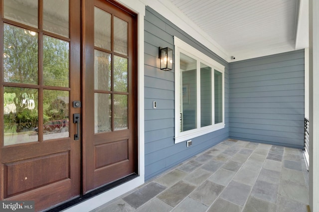 entrance to property with covered porch and a security system