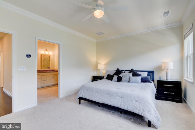 bedroom with ornamental molding, carpet, a sink, baseboards, and ensuite bath