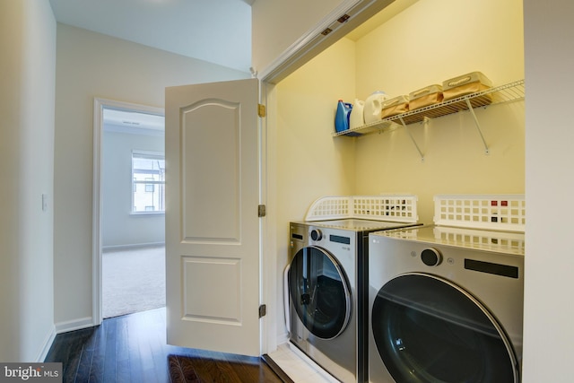 laundry room with washer and dryer, baseboards, and wood finished floors