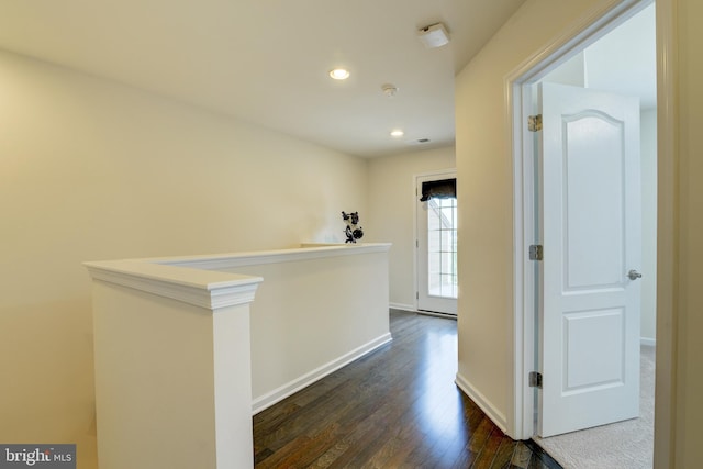 hall with dark wood-style flooring, an upstairs landing, recessed lighting, and baseboards