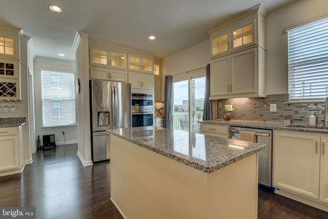 kitchen featuring appliances with stainless steel finishes, a center island, backsplash, dark wood-style floors, and recessed lighting