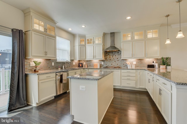 kitchen with wall chimney range hood, stainless steel appliances, a peninsula, backsplash, and recessed lighting