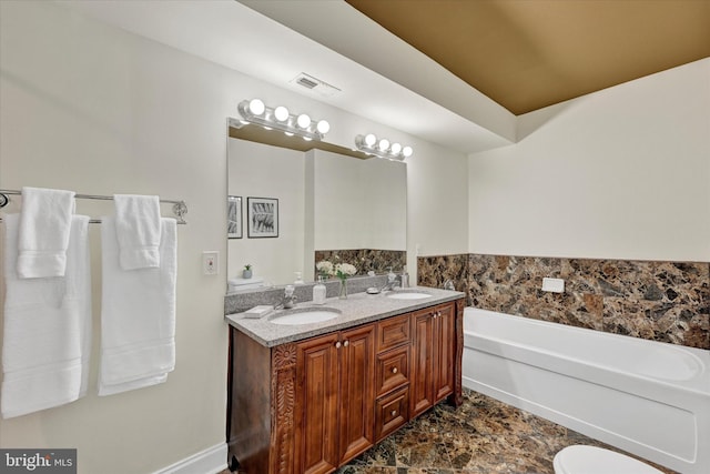 bathroom with a bath and double vanity