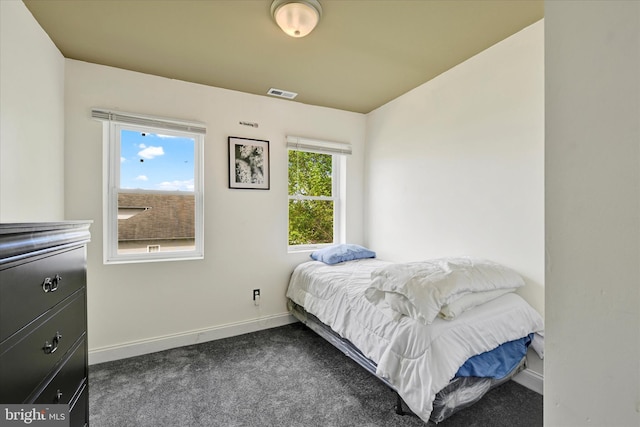 bedroom with baseboards and dark carpet