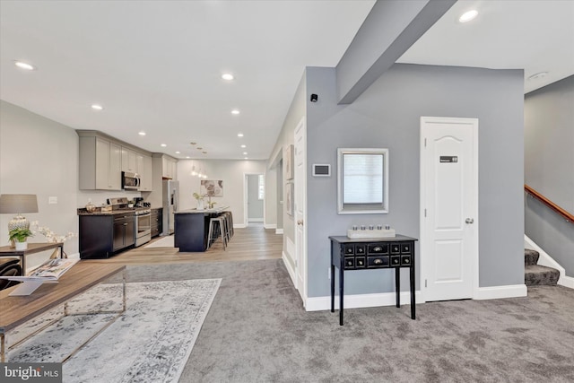 living area with light carpet, stairway, recessed lighting, and baseboards