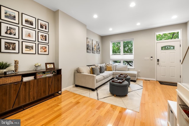 living area with baseboards, light wood-style floors, and recessed lighting