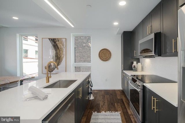 1501 N 31st St Unit 305, Philadelphia, PA 19121 - kitchen featuring appliances with stainless steel finishes, a sink, light countertops, dark wood-style flooring, and tasteful backsplash
