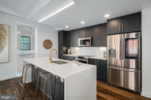 1501 N 31st St Unit 305, Philadelphia, PA 19121 - kitchen with stainless steel appliances, a sink, a center island with sink, dark wood-style floors, and tasteful backsplash