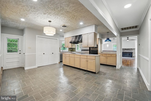 kitchen featuring light brown cabinets, baseboards, visible vents, wall chimney range hood, and appliances with stainless steel finishes