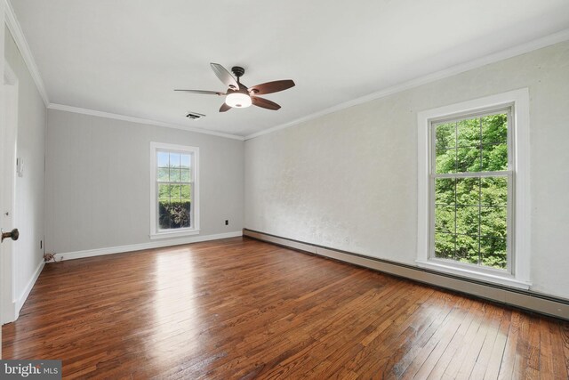 spare room featuring a ceiling fan, a baseboard heating unit, visible vents, wood-type flooring, and crown molding