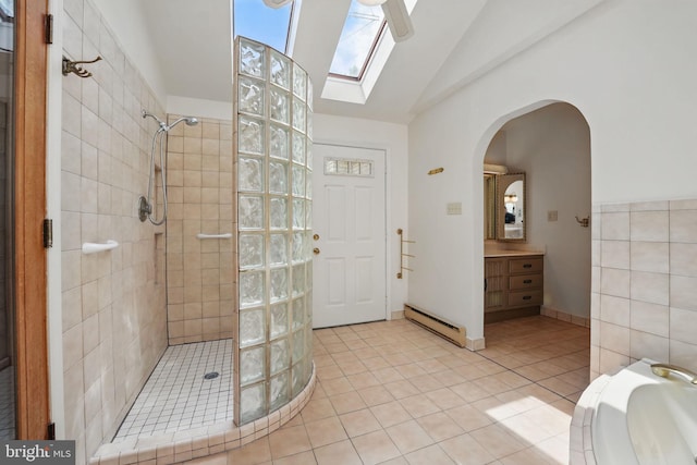 full bathroom featuring vaulted ceiling with skylight, vanity, tile patterned floors, a baseboard radiator, and a walk in shower