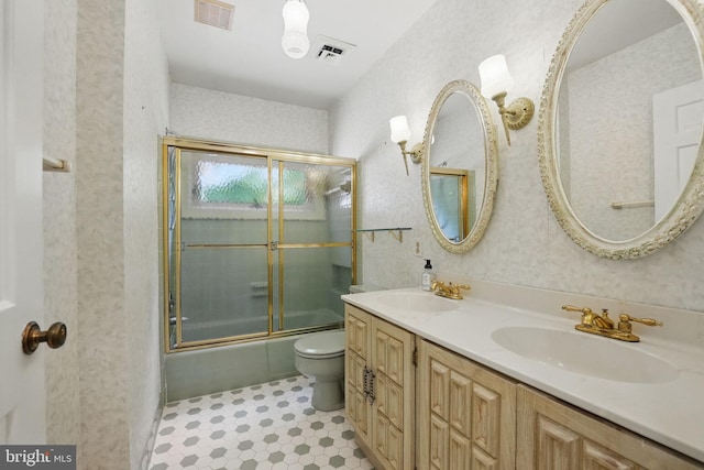 bathroom with a sink, combined bath / shower with glass door, toilet, and visible vents
