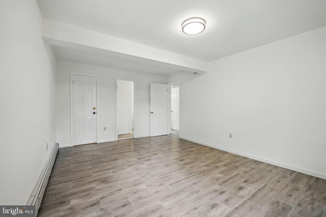 interior space featuring a baseboard radiator, baseboards, and wood finished floors
