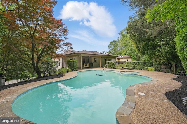 view of pool with a pool with connected hot tub, fence, a patio, and a ceiling fan