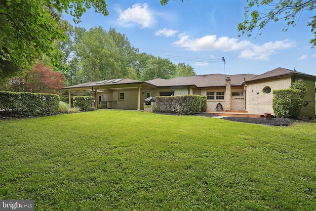 back of house with a yard and brick siding