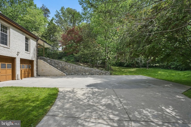 view of patio featuring an attached garage and driveway