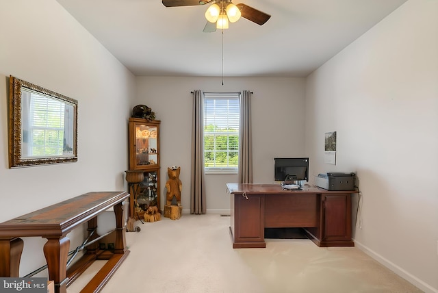 home office featuring light colored carpet, ceiling fan, and baseboards