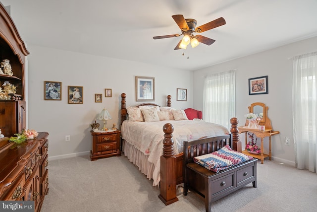 bedroom with light carpet, multiple windows, and baseboards