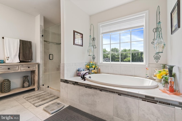 bathroom featuring tile patterned flooring, a shower stall, and a garden tub