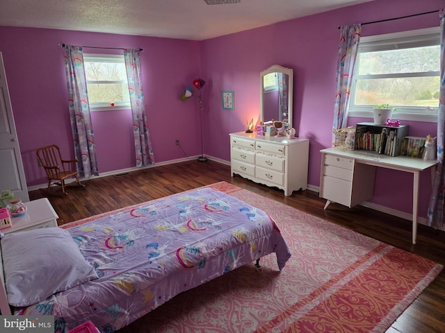 bedroom with wood finished floors and baseboards