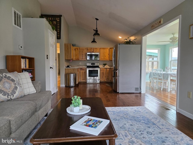living area featuring dark wood-type flooring, vaulted ceiling, ceiling fan, and baseboards