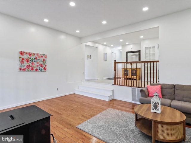 living room with wood finished floors, recessed lighting, baseboards, and stairway