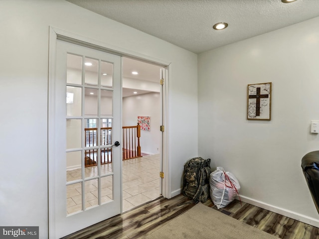 doorway with wood finished floors, baseboards, recessed lighting, and a textured ceiling