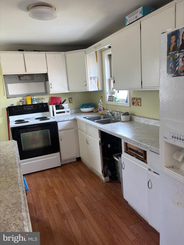 kitchen featuring electric range oven, light countertops, white cabinets, and a sink