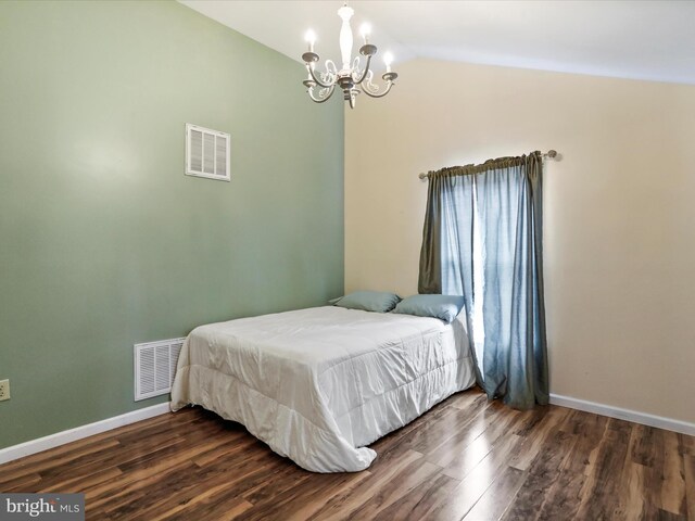 bedroom featuring a chandelier, dark wood finished floors, vaulted ceiling, and baseboards