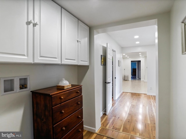 corridor with light wood-style flooring, baseboards, and recessed lighting