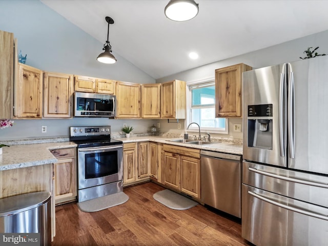 kitchen with appliances with stainless steel finishes, a sink, vaulted ceiling, light countertops, and dark wood-type flooring