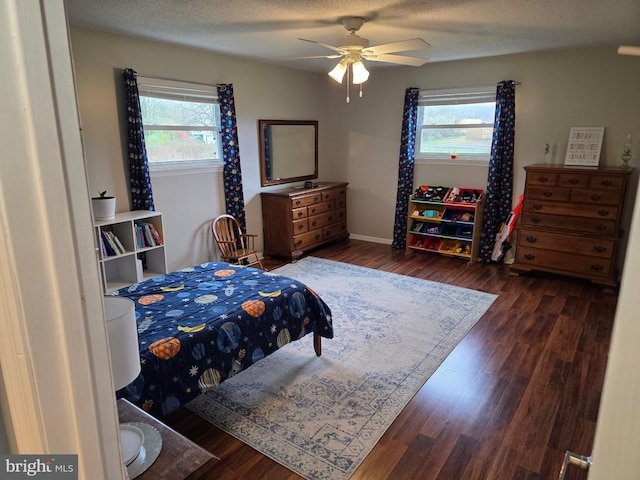 bedroom featuring multiple windows, wood finished floors, and a ceiling fan