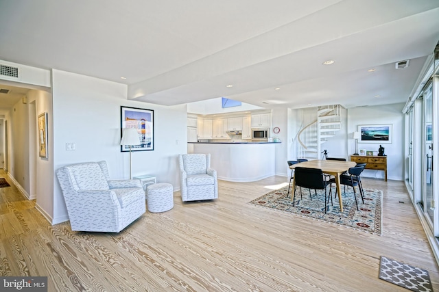 living area featuring stairway, light wood-style flooring, baseboards, and recessed lighting