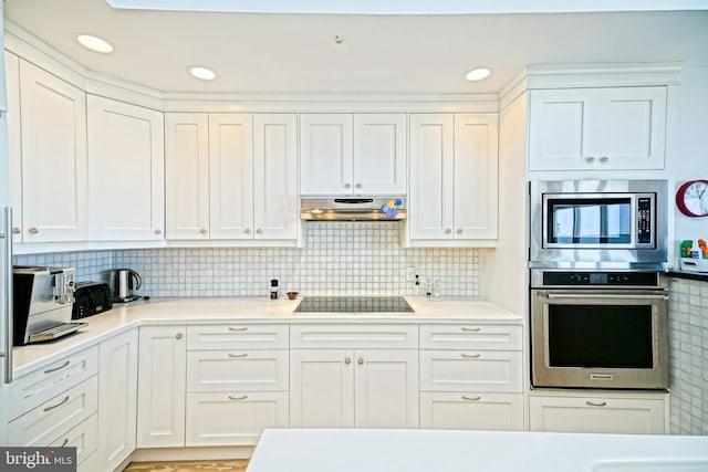 kitchen featuring stainless steel appliances, under cabinet range hood, white cabinets, and light countertops