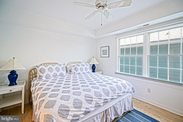 bedroom with wood finished floors, baseboards, and a ceiling fan