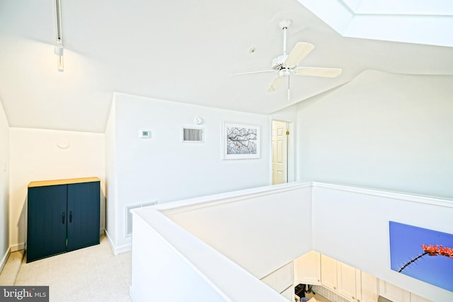 hall with lofted ceiling and light colored carpet