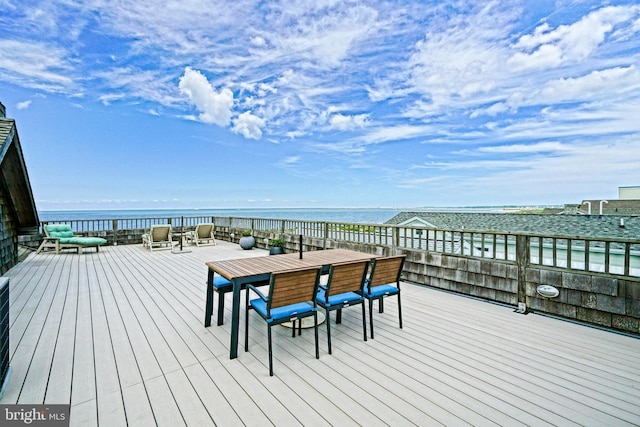 wooden terrace featuring a water view and outdoor dining space
