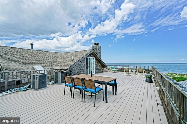 wooden deck with a water view, central AC, and outdoor dining area