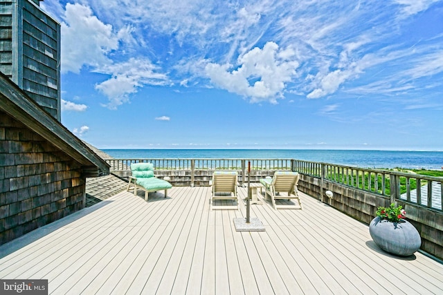 wooden terrace with view of water and beach