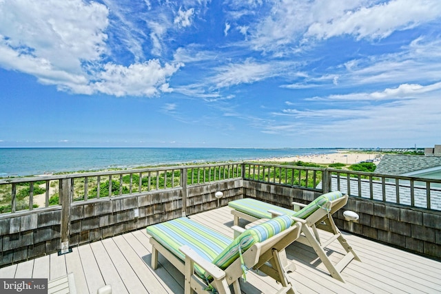 wooden terrace featuring view of water and beach